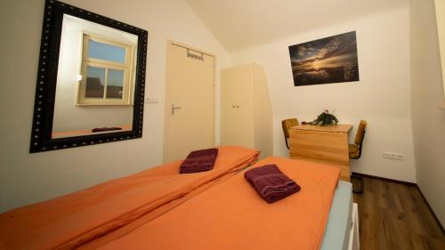 a bedroom with an orange bed and a mirror at Studio De Gravin in Gouda