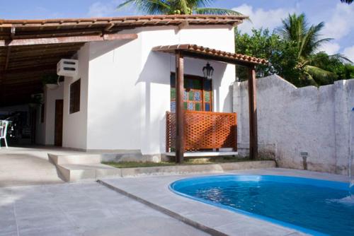 a swimming pool in front of a house with a pavilion at Dormitório Dourada Costa in Baía Formosa