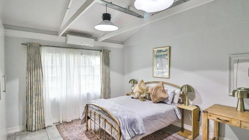 ein Schlafzimmer mit einem Bett und einem Fenster in der Unterkunft Cottage Protea in Doornrandjies
