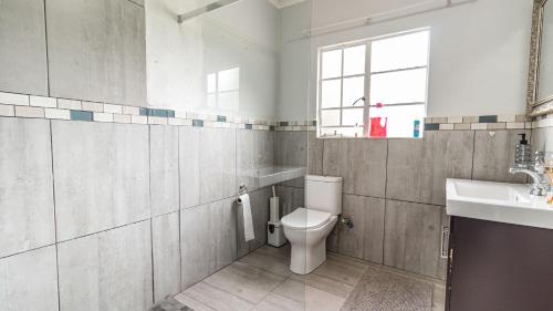 ein Badezimmer mit Toilette und Waschbecken in der Unterkunft Cottage Protea in Doornrandjies