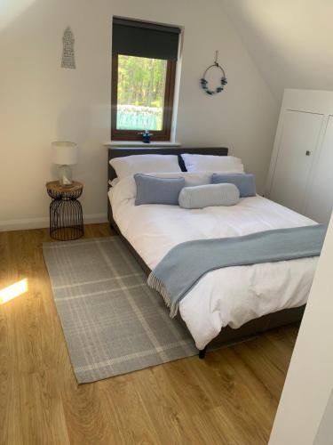 a bedroom with a large bed and a window at The Studio at Torr Leathann - Modern Studio in Stittenham