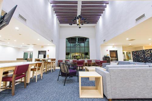 a lobby with couches and tables and chairs at Staybridge Suites Lafayette-Airport by IHG in Lafayette
