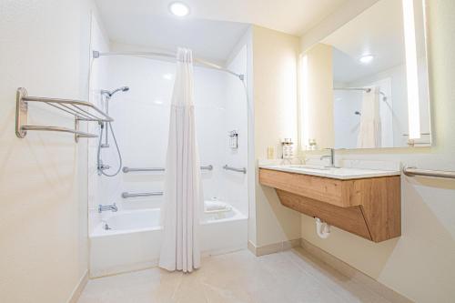 a white bathroom with a shower and a sink at Staybridge Suites Lafayette-Airport by IHG in Lafayette
