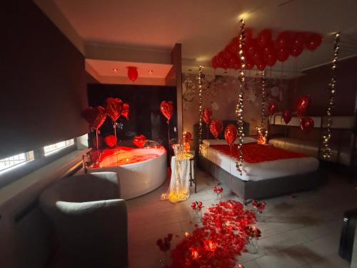 a bedroom with a tub and a bed with red decorations at B&B Golden House & spa in Rose