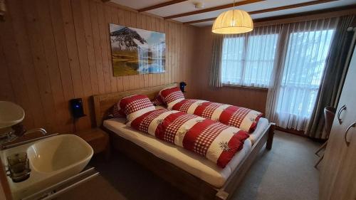 a bedroom with a bed with pillows and a sink at Chalet Suveran 2 in Arosa