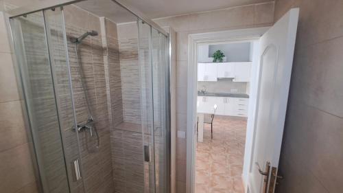 a bathroom with a glass shower with a sink at Casa Naihu in La Listada