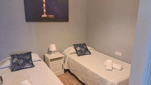 a room with two beds and a picture on the wall at Casa Naihu in La Listada