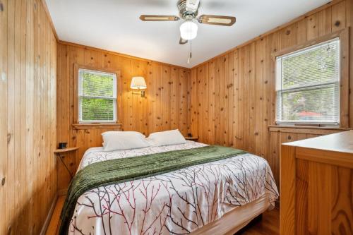 a bedroom with wooden walls and a bed in a room at Fish Creek Cottages in Fish Creek