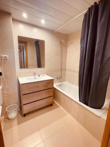 a bathroom with a sink and a tub and a mirror at Santa Clotilde in Lloret de Mar