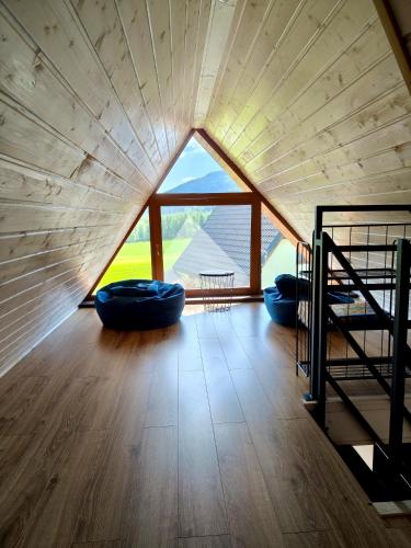 a room with a large window and two blue bean bags at Domki pod Derkaczem in Radków