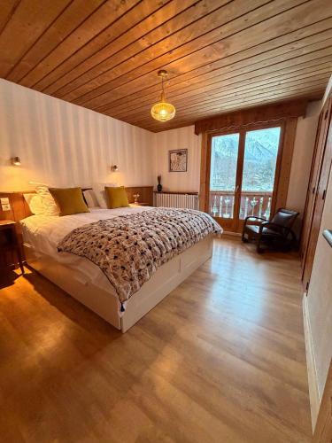 a bedroom with a large bed with a wooden ceiling at Chalet d'Honneur in Chamonix