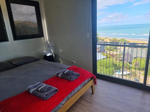 a bedroom with a bed and a view of the ocean at Gore Bay View, Tiny Pod, Treehouse in Gore Bay