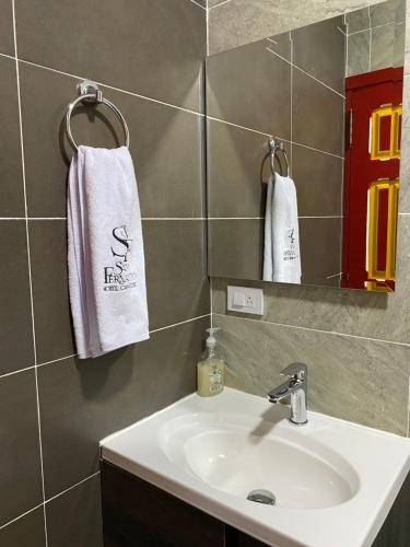 a bathroom with a sink and a mirror and towels at Hotel Campestre San Fernando in La Paloma