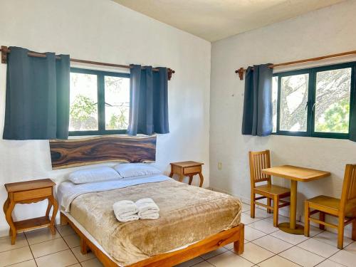 a bedroom with a bed with two towels on it at Incredible 360 views 5 min from downtown in Tepoztlán