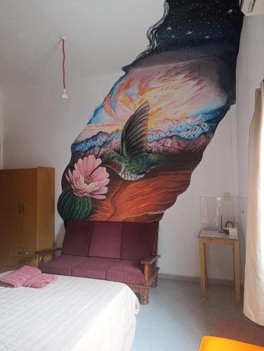 a painting of a bird on the wall of a bedroom at Kallpa in Tinogasta