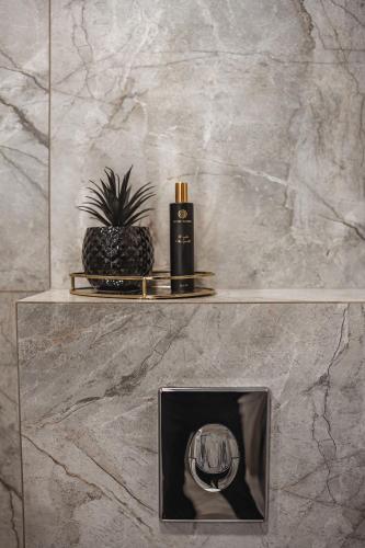 a bathroom with a pineapple on a shelf with a candle at Feliz Stay in Šiauliai