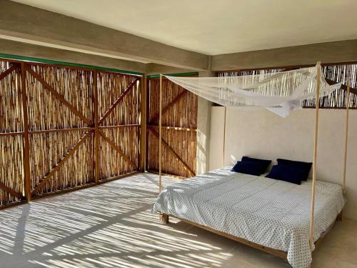 a bedroom with a bed with a mosquito net at Casa Chukum - Retreat House - Agua Blanca in Playa Agua Blanca