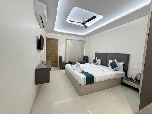 a bedroom with a large bed and a ceiling at Hotel Synergy Stays in Indore