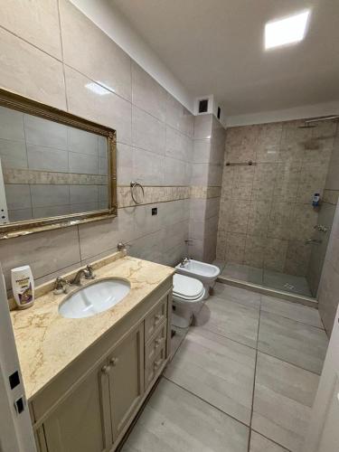 a bathroom with a sink and a toilet and a mirror at Casa Susana in Jesús María