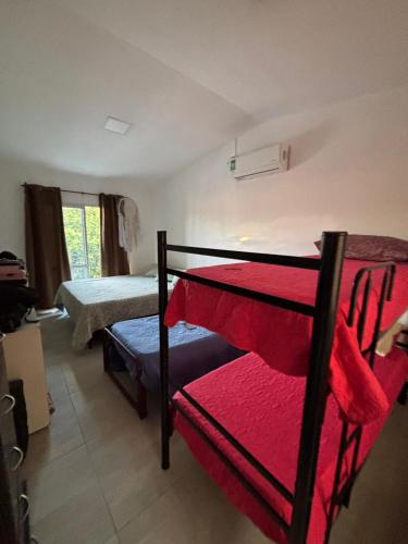 a bedroom with two bunk beds with red sheets at Casa Susana in Jesús María