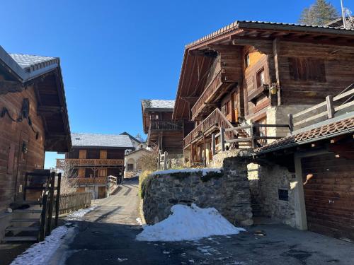 a snowy street in a town with wooden buildings at Chalet Les Marmouzets in Gryon