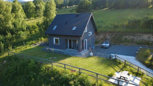 a small house with a car parked in a yard at Przystań w górskim Raju in Bolesławów