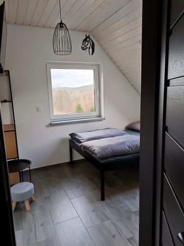 a small bedroom with a bed and a window at Przystań w górskim Raju in Bolesławów