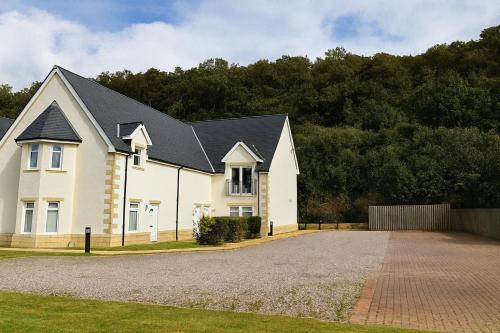 a large white house with a black roof at Conaglen, Glenloch View, Fort William 2-Bedroom Loch Side Flat in Fort William
