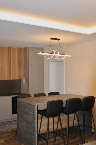 una cucina con un tavolo e sedie attorno di villadelight a Ferizaj