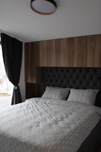 una camera da letto con un letto grande e una grande finestra di villadelight a Ferizaj