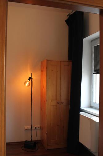 a room with a lamp next to a wooden cabinet at Kukucinova Apartments in Bratislava