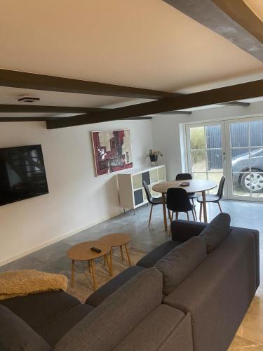 a living room with a couch and a table at House overlooking the countryside and close to the city in Middelfart