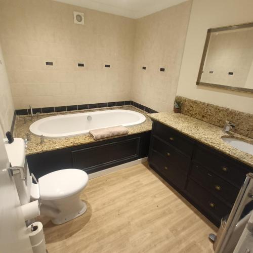 a bathroom with a tub and a toilet and a sink at Foxy stays in Tanfield