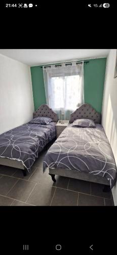 a bedroom with two beds and a window at La jonquiere etablisement climatisé in Landouzy-la-Cour