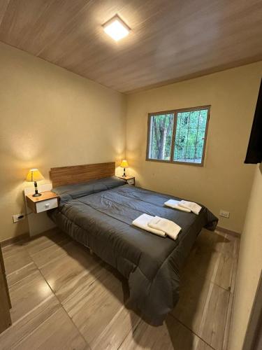 a bedroom with a large bed with two towels on it at El Atardecer in Trapiche