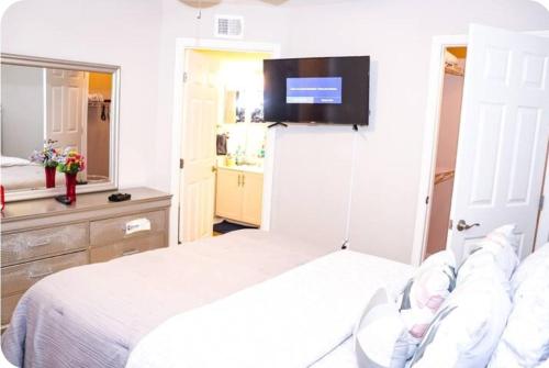 a bedroom with a bed with a tv on the wall at The Monthly stay Apartment for 8, pool and grill in Greensboro