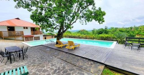 una piscina con sedie e tavoli e un albero di Clave Verde Ecolodge a Las Terrenas