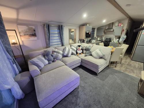 a living room with a couch and a teddy bear at Cayton Bay Holiday Park Kestrel40 in Scarborough
