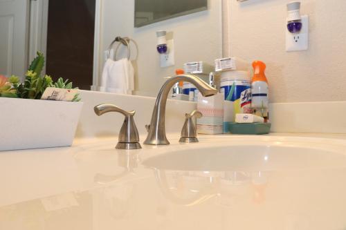 a bathroom sink with a faucet and a mirror at The Monthly stay Apartment for 8, pool and grill in Greensboro