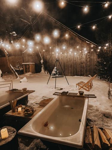 a bath tub in a room with snow and lights at Okno w Gorce- 1 apartament z BALIĄ na wyłączność- Gorce, Pieniny, jezioro Czorsztyńskie in Maniowy