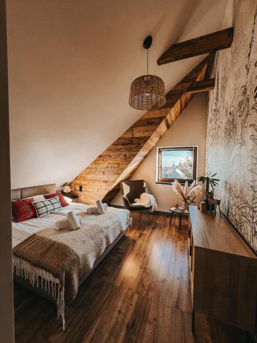 a bedroom with a large bed and a staircase at Okno w Gorce- 1 apartament z BALIĄ na wyłączność- Gorce, Pieniny, jezioro Czorsztyńskie in Maniowy