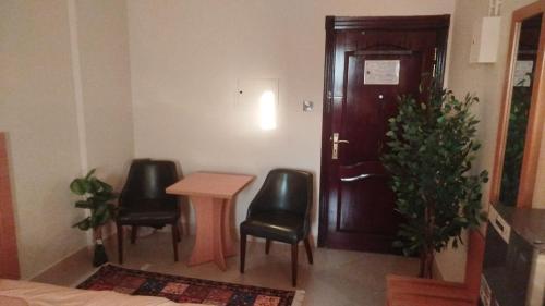 a room with a table and two chairs and a door at EL Salam in Hotel Apartment 6 in Sharjah