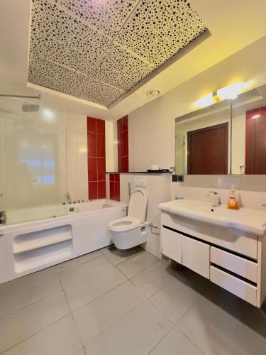 a bathroom with a tub and a toilet and a sink at One Bedroom apartment Centaurus Islamabad in Islamabad
