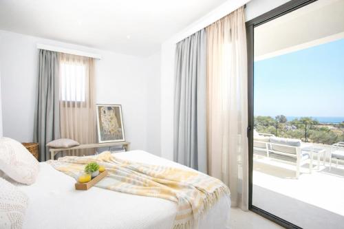 a bedroom with a bed and a view of the ocean at Exclusive Olive & Herb Villa, Mountain to Sea Views, Rhodes in Afantou