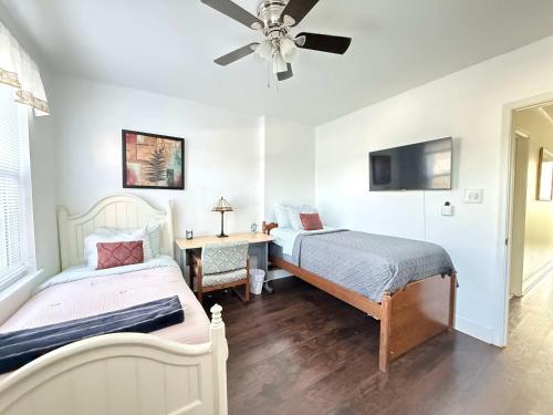 a bedroom with two beds and a ceiling fan at Cozy spacious family home near Carytown fully fenced in Richmond