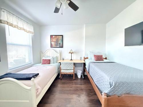 two beds in a room with a desk and a table at Cozy spacious family home near Carytown fully fenced in Richmond