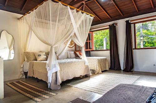 a bedroom with two beds with mosquito nets at La hospedaria in Trancoso