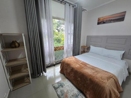 a bedroom with a bed and a large window at Zachi Eland Apartment in Kitwe