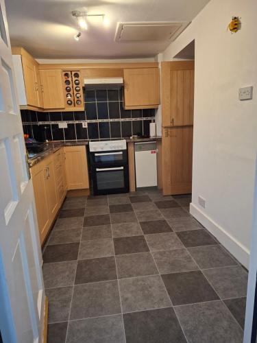 a kitchen with wooden cabinets and a tile floor at Number 2 in Montrose