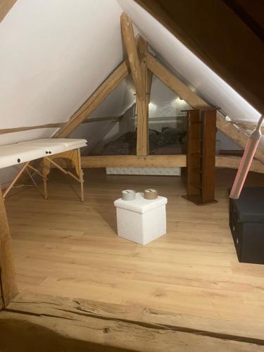 a attic room with a bench and a table at Escapade & Bien être in Ravenel